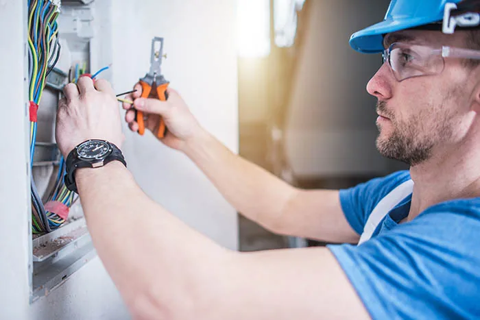 Electricista trabajando en el cableado de un tablero eléctrico en Lurín